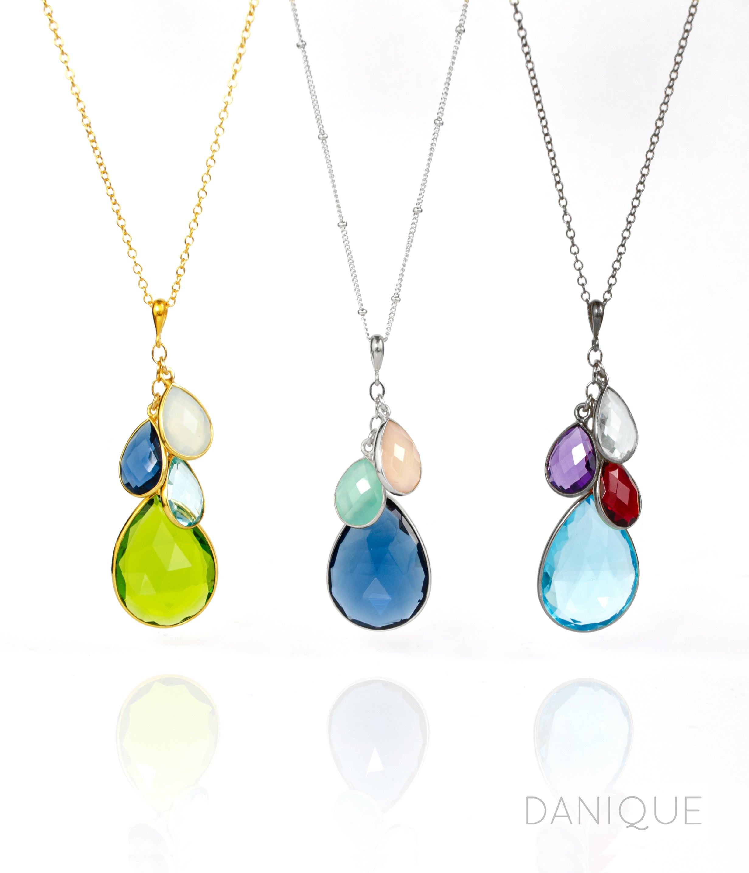 Single gold filled cable style cascade chain with large mother's peridot birthstone and three kid's stones including moonstone, kyanite and blue topaz. Middle necklace is sterling silver satellite chain with kyanite mother stone, aqua and pink chalcedony for children's stones and a oxidized cascade necklace with blue topaz, clear, purple amethyst and ruby birthstones
