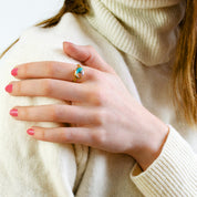 Model in white sweater is wearing sterling silver Oval mohave copper turquoise ring, december birthstone ring, blue purple gemstone, Bezel set, Sterling silver or gold, faceted ring, december gift