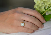 Model is wearing a Moonstone gold plated cushion bezel square White topaz pave stacking ring.