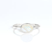 a sterling silver rainbow moonstone ring shown on white background. stackable! Stacking rings, bezel set, small oval, tiny oval, dainty oval, birthstone rings, sterling silver stamp, birthstone ring, birthstone jewelry, white iridescent gemstone, moonstone birthstone, june birthstone, june gemstone. stack set, stacking rings, gemstone ring, birthstone ring, mother's day gift for her, gift for mom, gift for fiance, gift for girlfriend, wedding jewelry, bridesmaid jewelry, anniversary jewelry, christmas gift