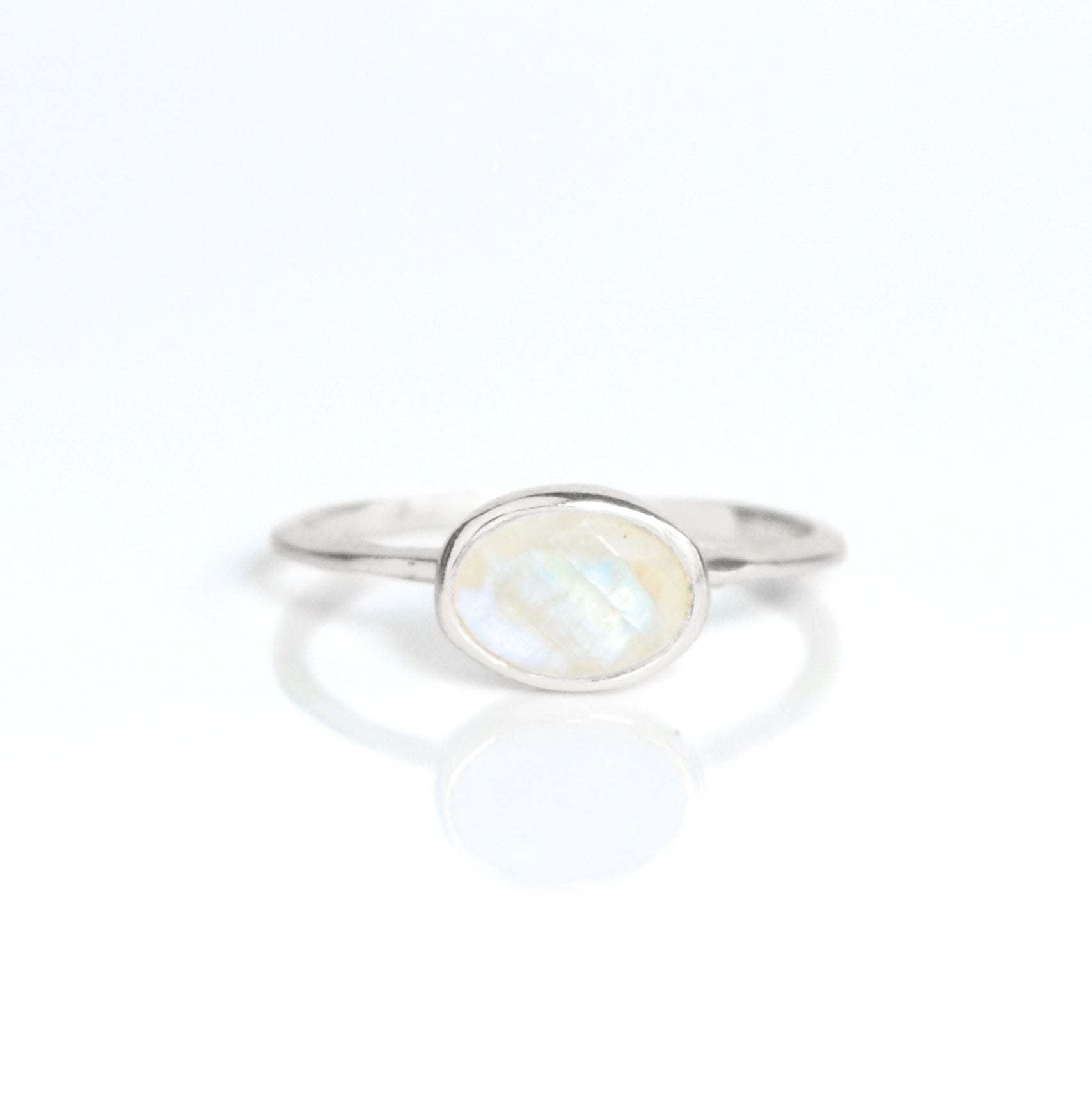 a sterling silver rainbow moonstone ring shown on white background. stackable! Stacking rings, bezel set, small oval, tiny oval, dainty oval, birthstone rings, sterling silver stamp, birthstone ring, birthstone jewelry, white iridescent gemstone, moonstone birthstone, june birthstone, june gemstone. stack set, stacking rings, gemstone ring, birthstone ring, mother's day gift for her, gift for mom, gift for fiance, gift for girlfriend, wedding jewelry, bridesmaid jewelry, anniversary jewelry, christmas gift