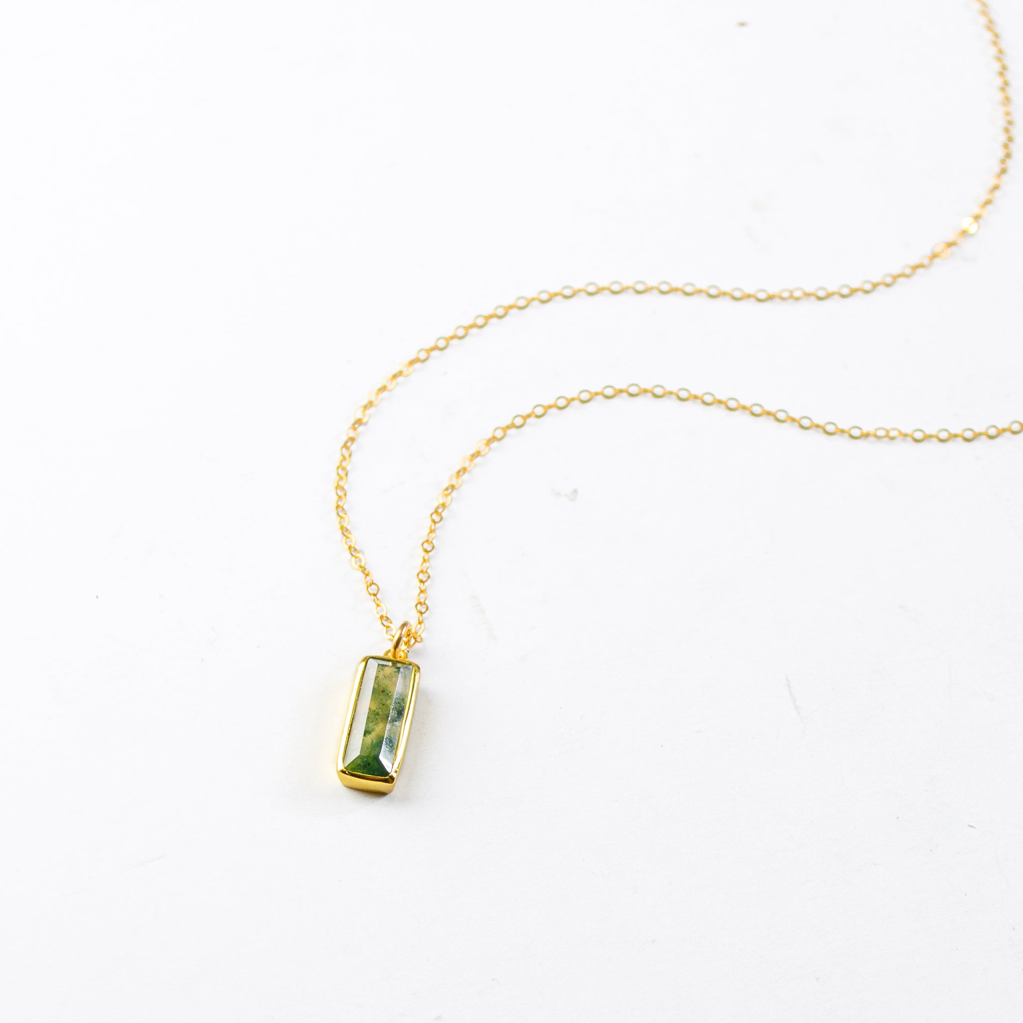 Single gold filled cable chain with vertical moss agate adira bar necklace on white background