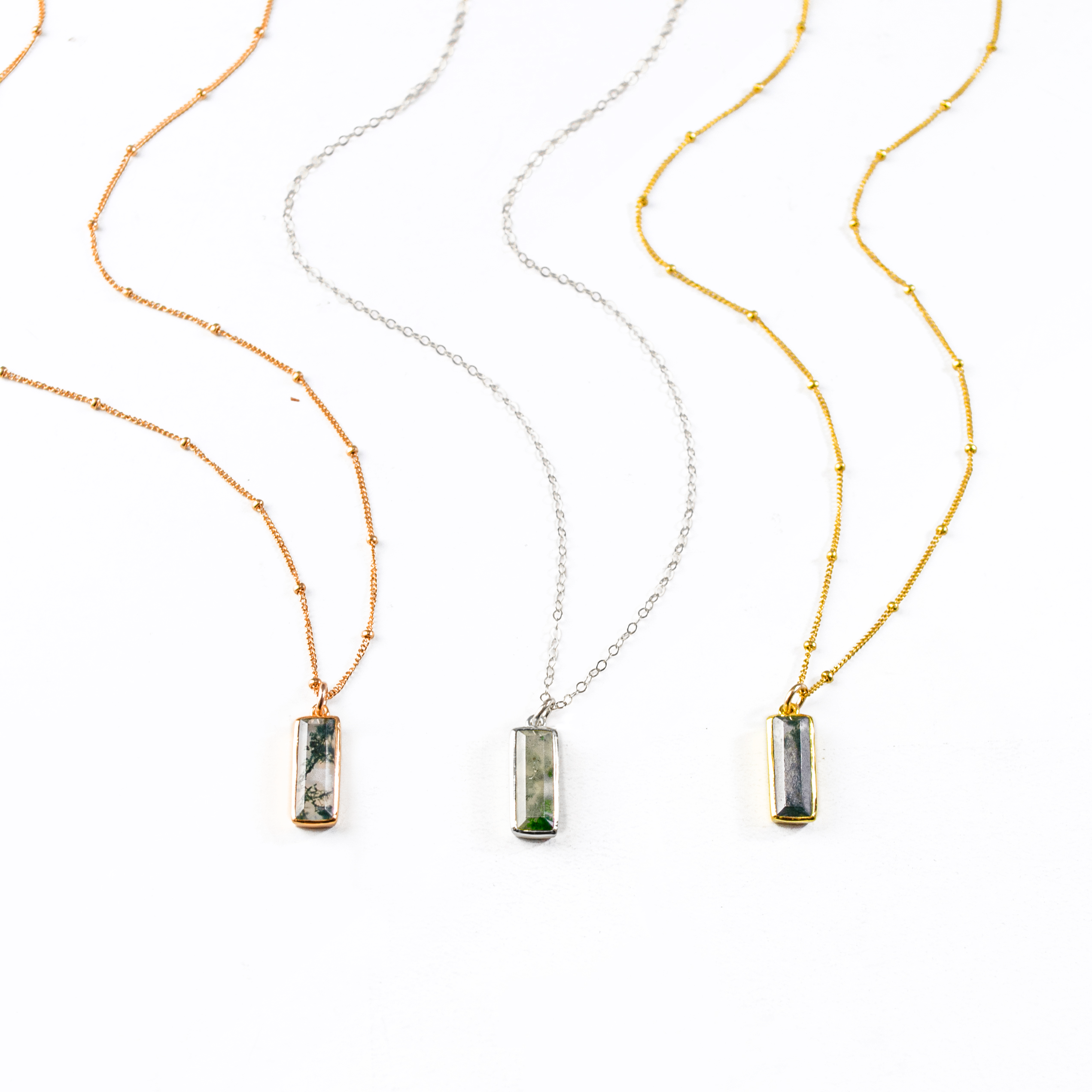 Single rose gold filled satellite chain with vertical moss agate adira bar necklace; Single sterling silver cable chain with vertical moss agate adira bar necklace, Single gold filled satellite chain with vertical moss agate adira bar necklace on white background