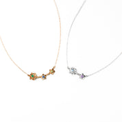 Rose gold mom of two bloom necklace with green onyx, kyanite and peridot birthstones. Sterling silver mom of one bloom necklace with sky blue and purple amethyst birthstones on a white background. 