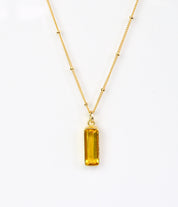 Single gold filled satellite chain vertical citrine november birthstone adira bar necklace on white background.