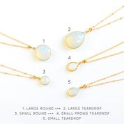 Collection of opalite birthstone necklaces with round and teardrop pendants on display cards. October birthstone jewelry handmade in Massachusetts — a thoughtful jewelry gift for her, bridesmaid, or mom. Dainty opal necklace in gold, silver, and rose gold finishes.