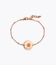 Single rose gold satellite chain with lobster clasp and paw print disc with pet name in typewriter font. 
