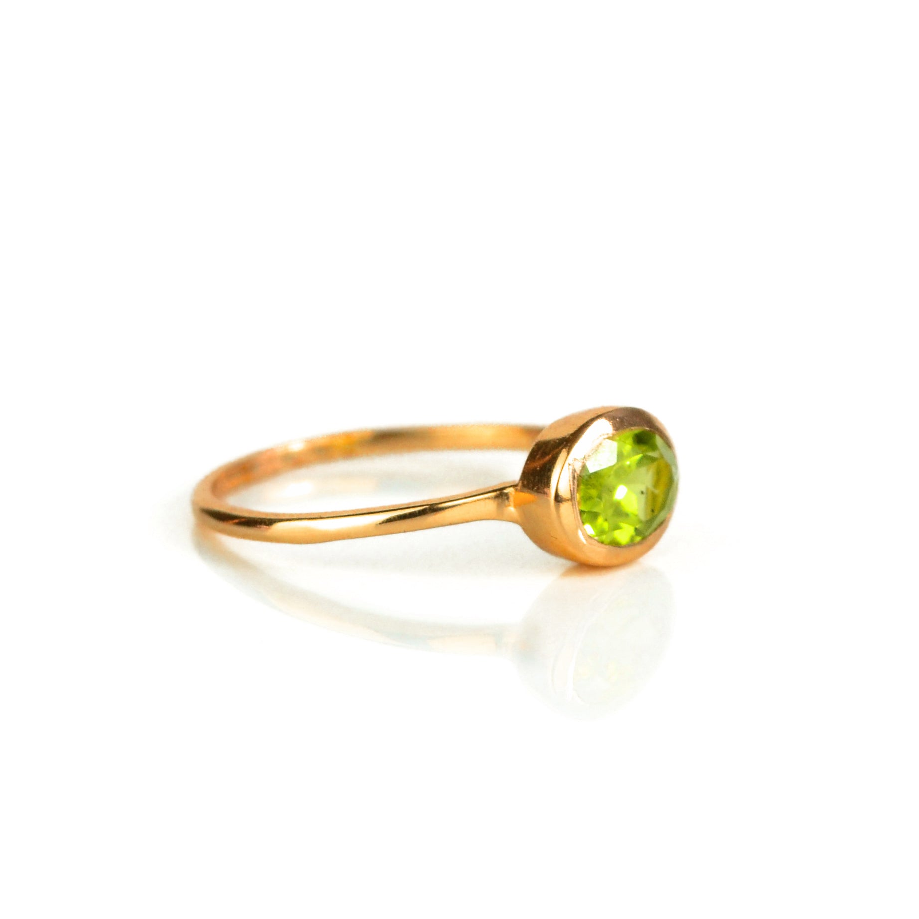a rose gold peridot ring shown on white background. stackable! Stacking rings, bezel set, small oval, tiny oval, dainty oval, birthstone rings, sterling silver stamp, birthstone ring, birthstone jewelry, green gemstone, peridot birthstone, august birthstone, august gemstone. birthstone jewelry, august birthstone, august birthday, green ring, peridot birthstone. stack set, stacking rings, gemstone ring, birthstone ring, mother's day gift for her, gift for mom, gift for fiance, gift for girlfriend 
