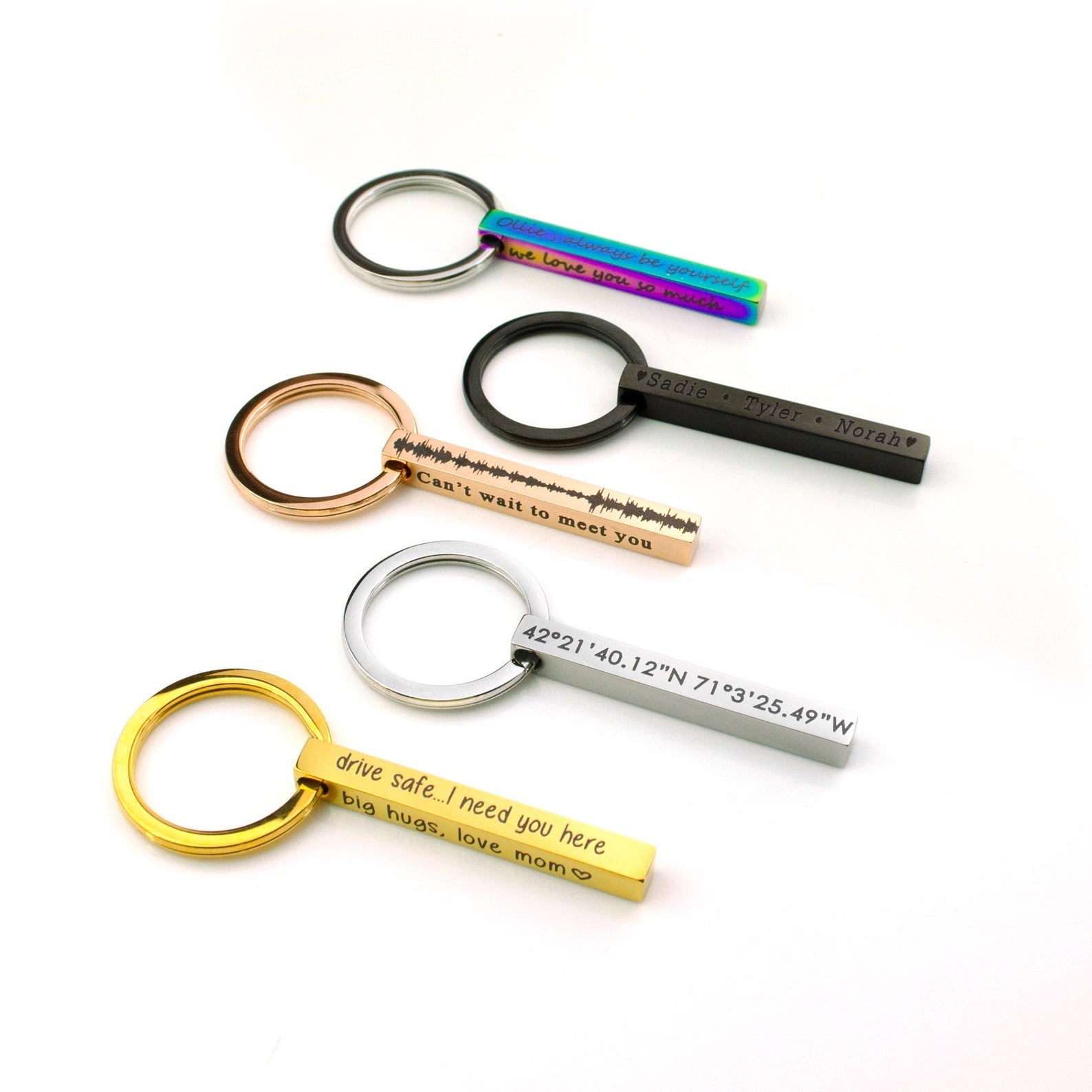 Sleek 3D bar keychains in silver, gold, rose gold, black, and rainbow finishes arranged on a white background, each engraved with custom names, dates, or short messages. Modern personalized keyring set shows scale, polish, and color options—ideal for groomsmen gifts, new-driver “drive safe” presents, and long-distance coordinates keychain ideas for him or her.