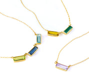 Personalized baguette-cut birthstone bar necklaces in sterling silver, gold filled, and rose gold, each with rectangular bezel settings. Customize with engraved names or secret messages to create a sentimental birthstone jewelry gift for mom or grandmother. Choose from January Garnet, February Amethyst, March Aquamarine, May Emerald, July Ruby, September Sapphire, December Blue Topaz, and more to represent your family.