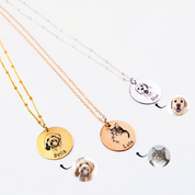 Three pet engraved disk necklaces are pictured. The first necklace is a satellite gold filled chain with modern thin font engraved name, middle rose gold cable chain necklace with cat and name engraved in classic font and a sterling silver satellite chain with a dog and name engraved in typewriter font. 