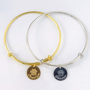 One gold bangle bracelet with stock paw print and name engraved on the front. One silver bangle disc bracelet with stock paw print and name engraved on the front.