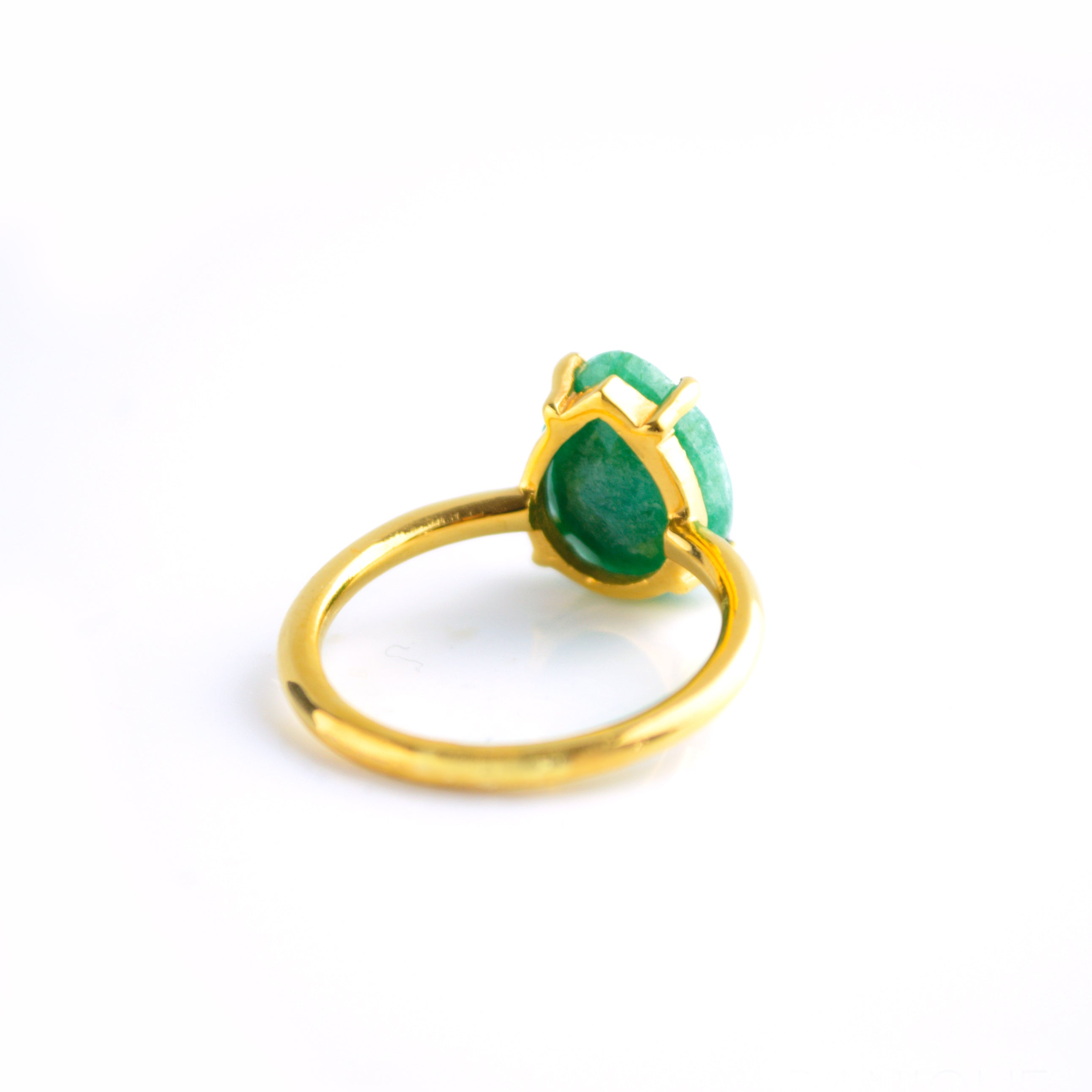Rear view of a gold teardrop emerald ring showing the raised open prong setting, slim band, and gemstone profile.