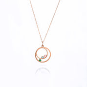 Single orbital necklace in rose gold filled cable chain with two orbits small ring with aqua chalcedony and pink chalcedony and larger ring with green onyx birthstone. 
