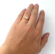 Model is wearing a gold plated moonstone stackable prong set round ring. Birthstone jewelry, birthstone ring, stacking rings, ring stack, gemstone ring, gemstone rings