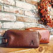 Engraved men's toiletry bag, personalized dopp kit, custom men's Rustic men’s leather toiletry bags engraved with initials, photographed against wood and seasonal décor. Perfect Christmas gift idea for men, husbands, or groomsmen.
