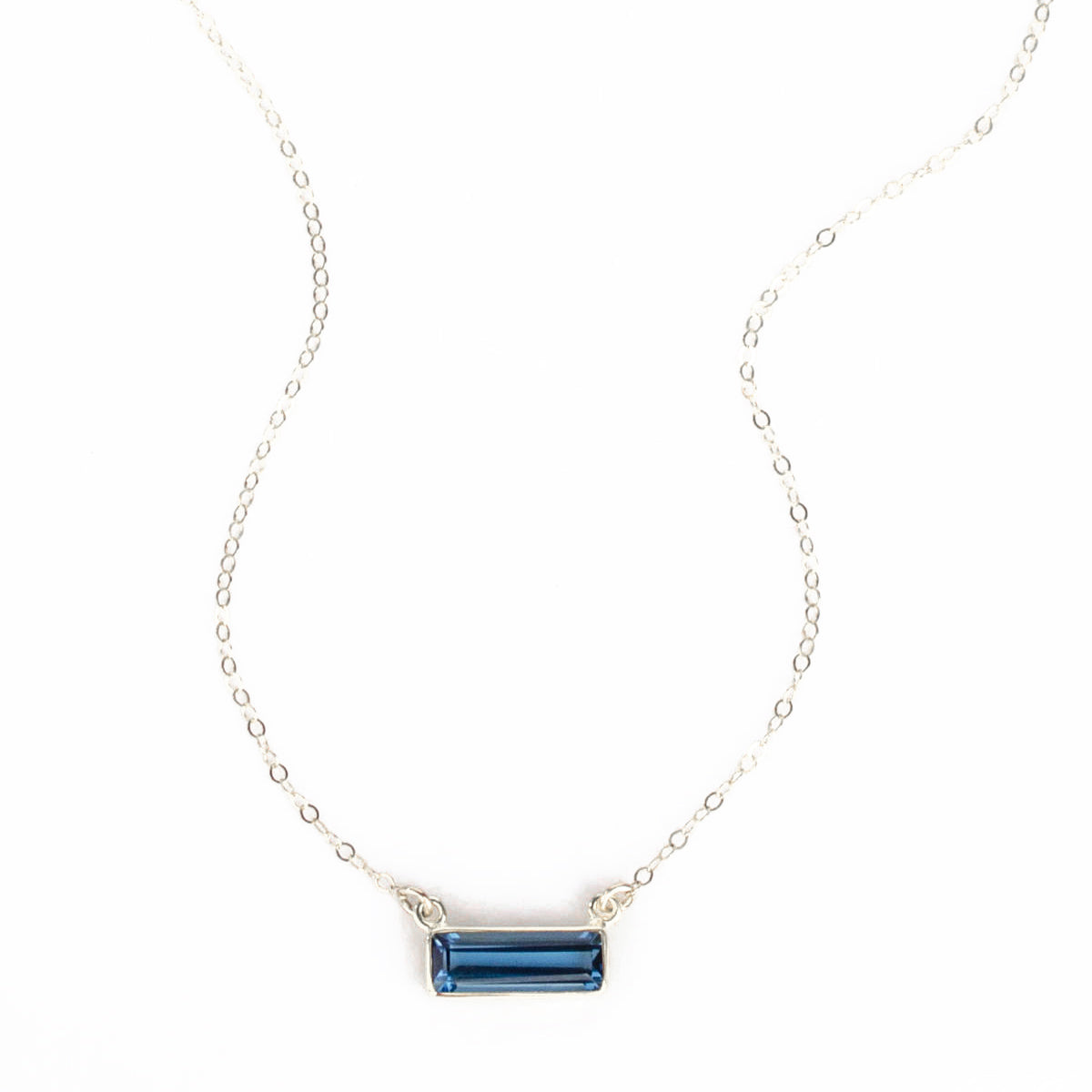 Single sterling silver cable chain with horizontal september kyanite birthstone bar on white background