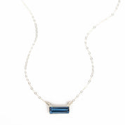 Single sterling silver cable chain with horizontal september kyanite birthstone bar on white background