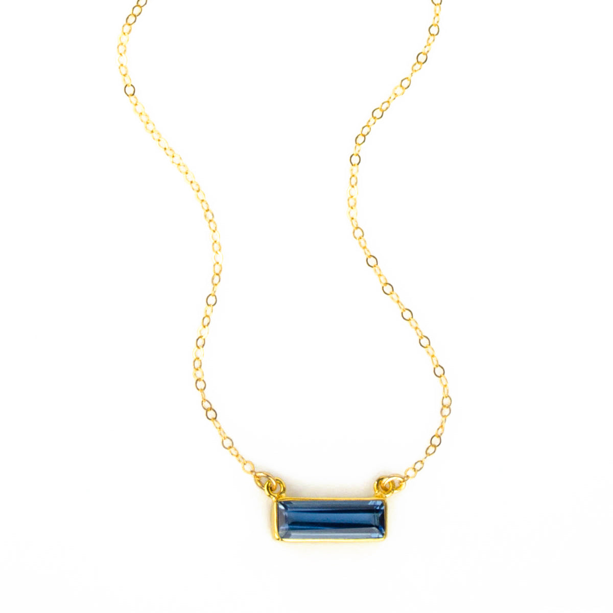 Single gold filled cable chain with horizontal september kyanite birthstone bar on white background