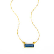 Single gold filled cable chain with horizontal september kyanite birthstone bar on white background