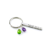 Clean studio image showing a silver kids name keychain with a slim engraved bar and two vibrant birthstone drops. The modern spring ring keeps the profile sleek while the compact 40×4 mm bar supports names, initials, or date keychain engraving on multiple sides. A sweet, minimalist way to celebrate children or grandchildren for Mother’s Day or birthdays.