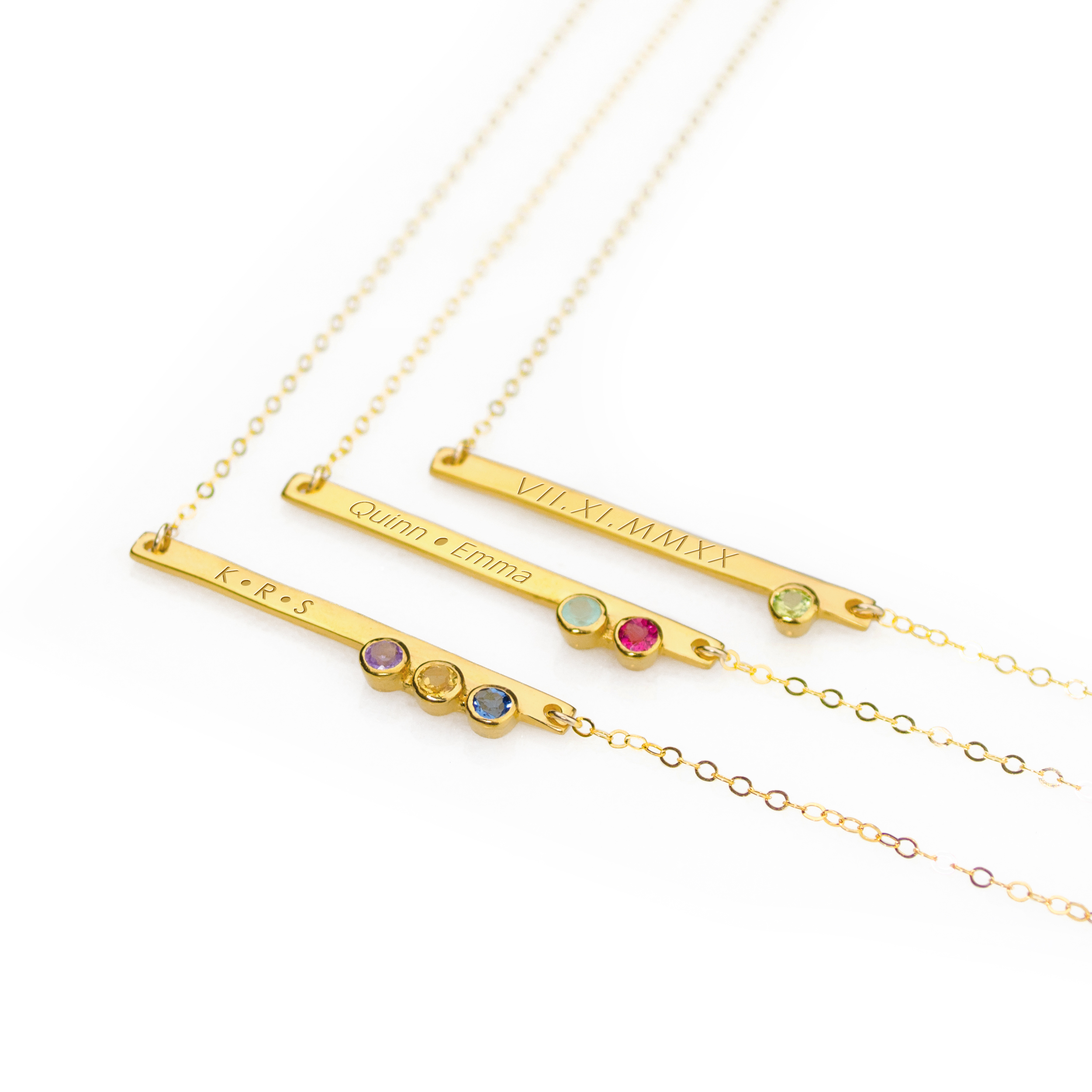 Gold plated skinny bar with 1 peridot gemstone and roman numerals, center necklace has two names engraved with aqua chalcedony and ruby gemstones, last necklace has initial engraved with the purple amethyst, citrine and iolite birthstones. 