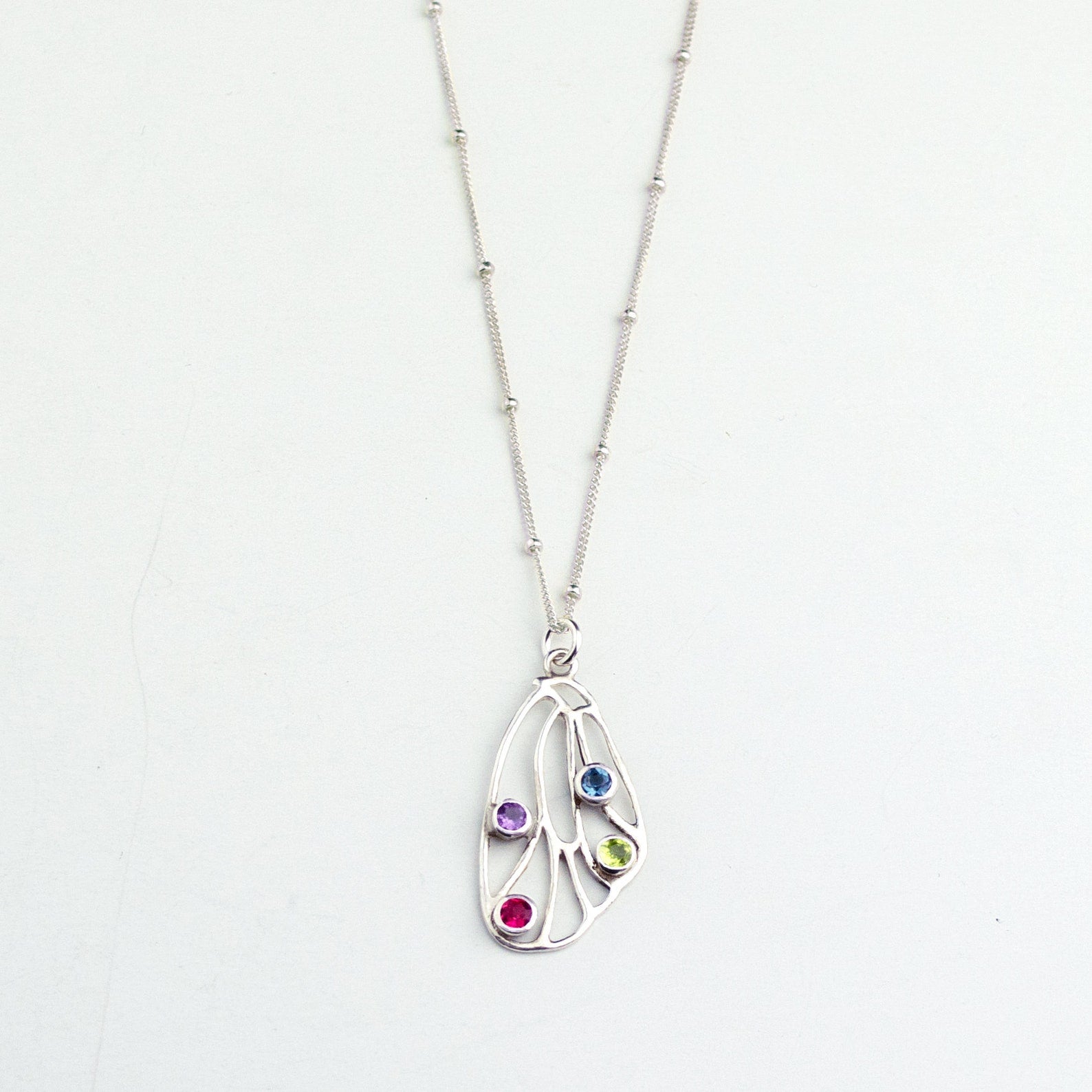 Sterling silver Butterfly pendant wing birthstone necklace satellite chain and purple amethyst, ruby, iolite and peridot gemstones. 