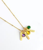 Single gold filled satellite chain with tiny engraved name bars and purple amethyst, citrine and green onyx birthstones. Gemstones on a white background. 