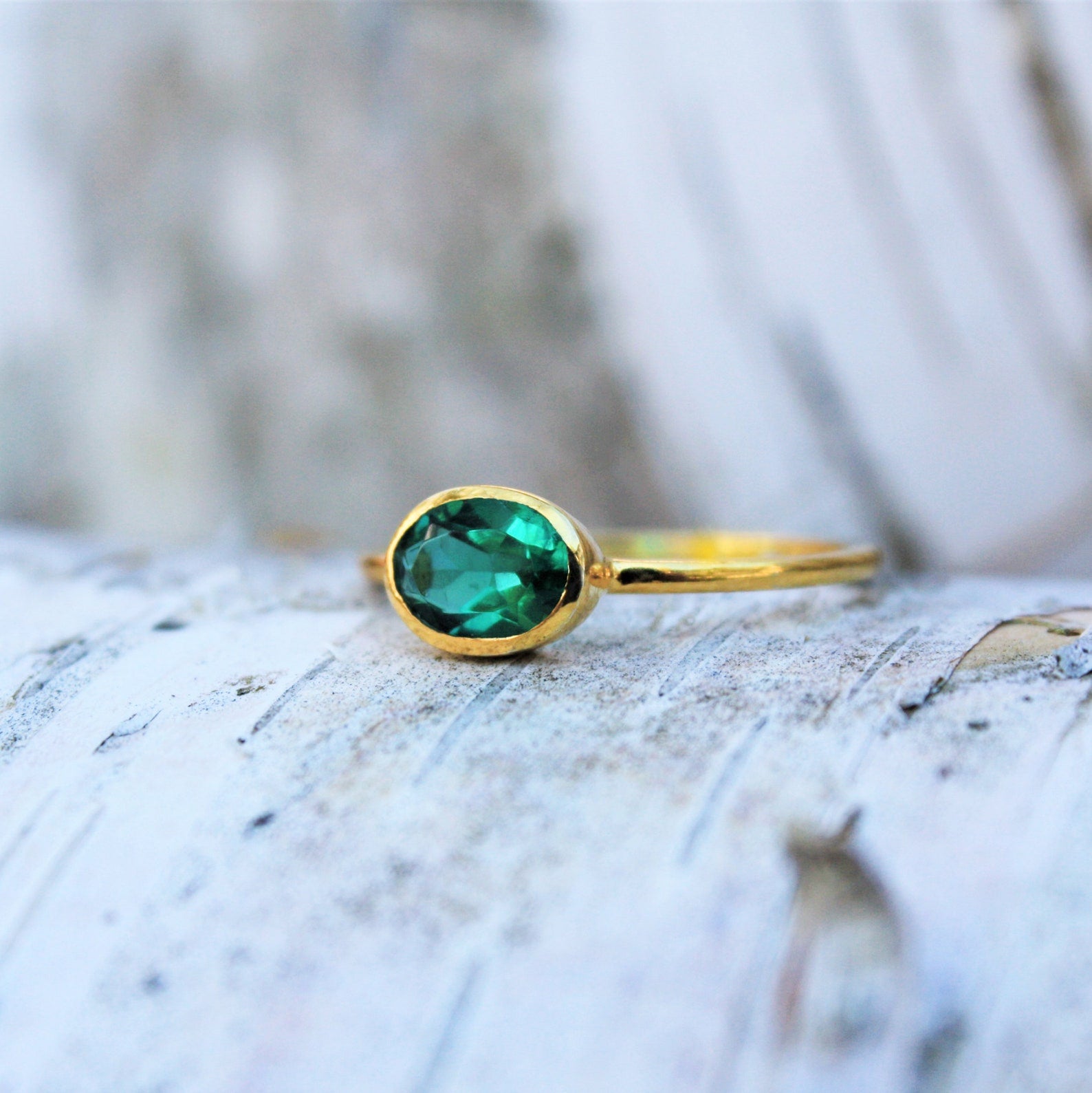 a rear view of a gold green tourmaline ring shown on white background. stackable! Stacking rings, bezel set, small oval, tiny oval, dainty oval, birthstone rings, sterling silver stamp, birthstone ring, birthstone jewelry, green gemstone, green birthstone, october birthstone, october gemstone, mother's gift, gift for sister