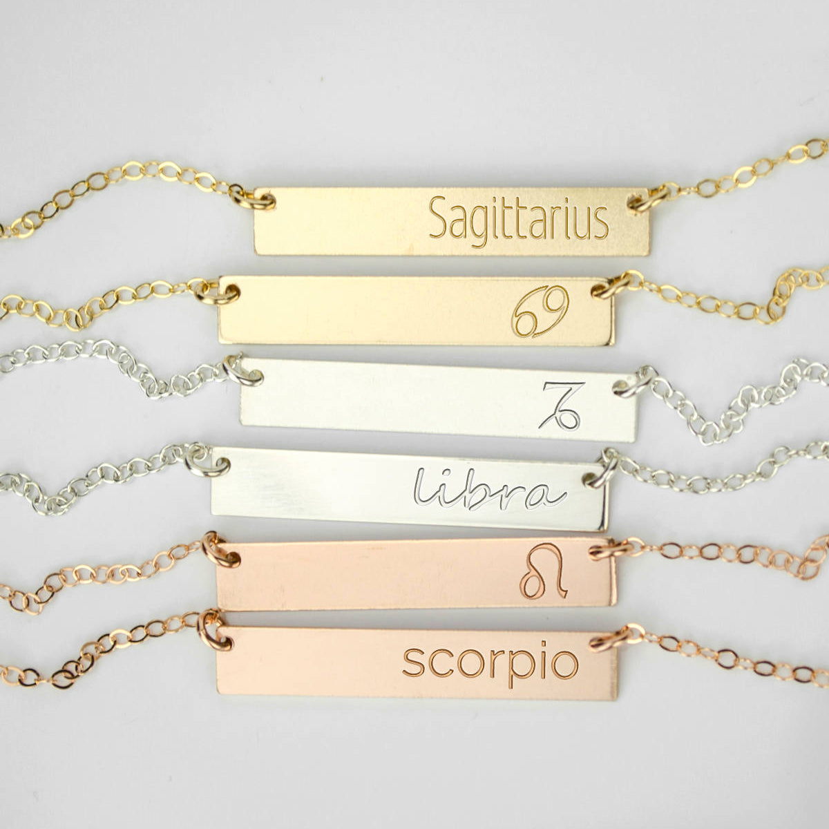 6 zodiac signs in different styles sit on a gray background. Custom name engraved bar necklace Personalized bar pendant for women Minimalist engraved bar charm necklace Custom message bar necklace Engraved bar necklace for her Personalized engraved coordinates pendant Minimalist bar necklace with custom engraving Custom bar necklace for weddings Engraved minimalist necklace for men
